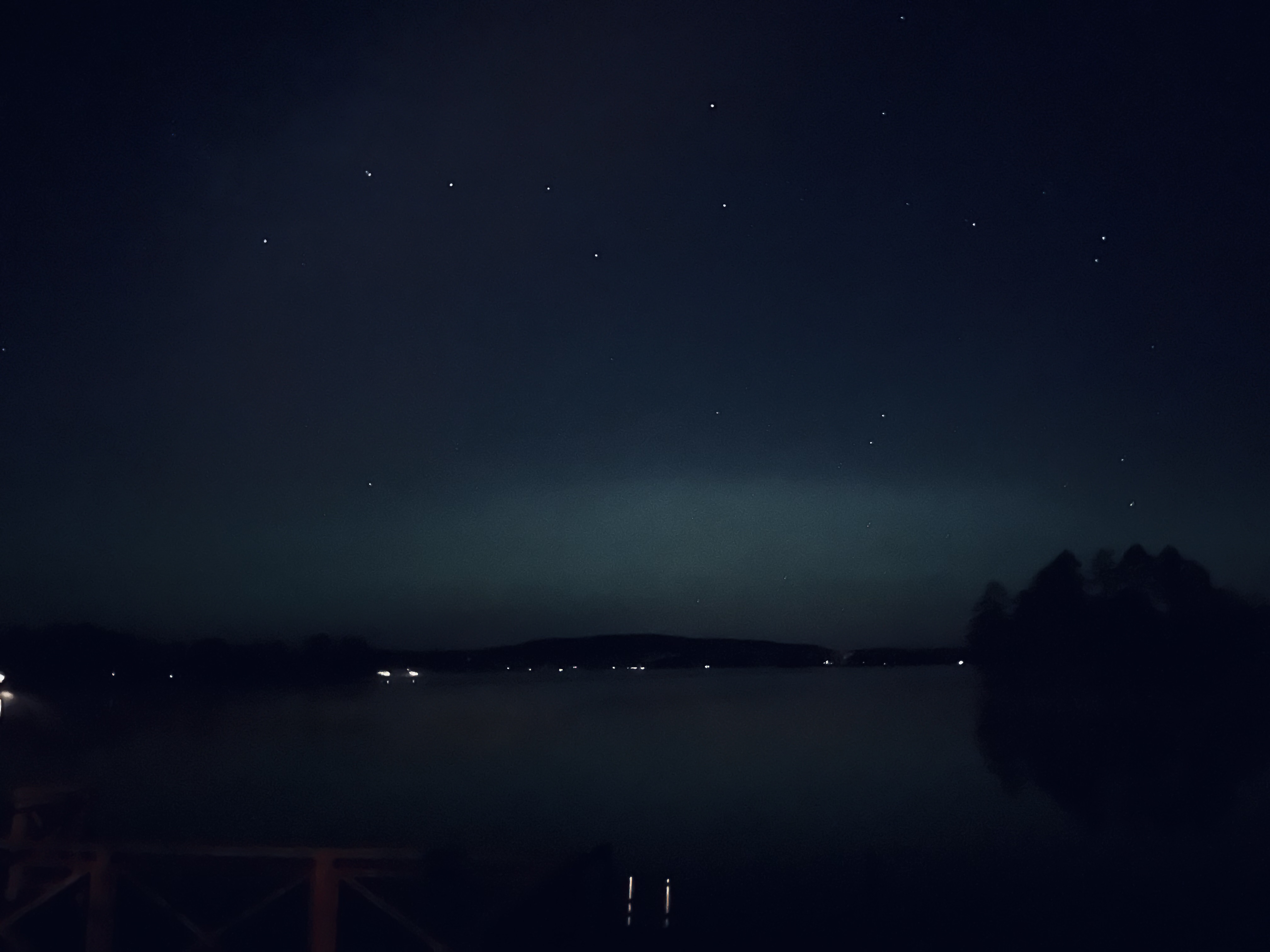A photo of a starry sky above a lake.